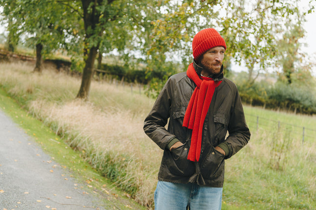 Man outside wearing red knitted hat and scarf set
