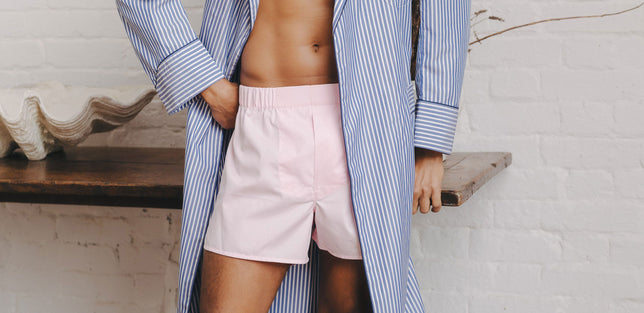 Male model wearing pink boxer shorts and blue striped gown