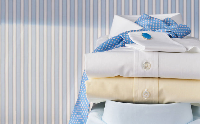 Stack of shirts in pile on stripe blue and white background