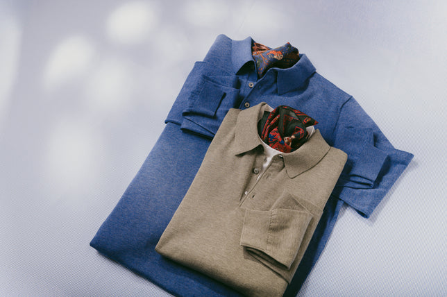 Two knitted long sleeve polo shirts in blue and beige laid on white background