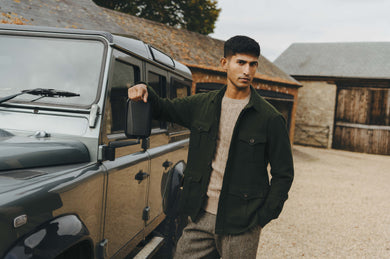 Man standing next to a Land Rover vehicle in a rural setting