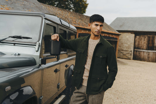 Man standing next to a Land Rover vehicle in a rural setting