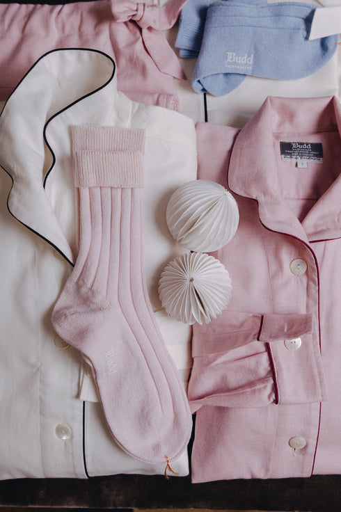 Pink pajama set with matching socks and blue socks on a white background