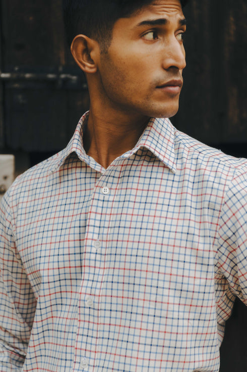 Man wearing a checkered shirt against a dark background