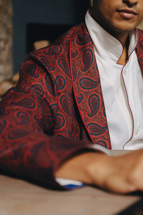 Person wearing a red paisley patterned night gown over a white pyjama set