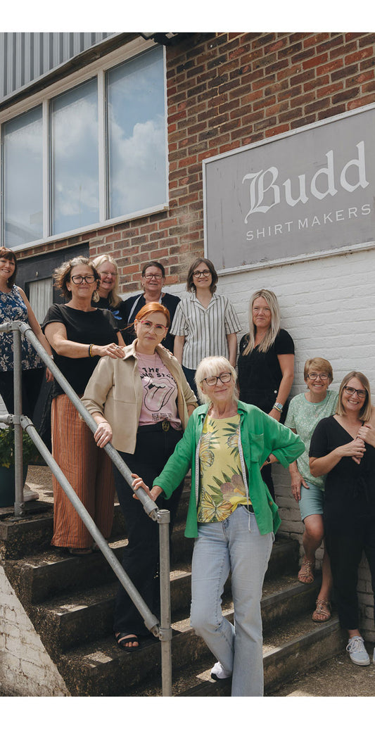 Andover workroom team posing in front of a building with 'Budd Shirtmakers' sign.