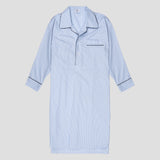 A light blue and white vertically striped long-sleeve pajama shirt dress with dark piping trim on the collar, placket, cuffs, and chest pocket, shown flat against a light gray background.