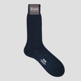 A single dark navy blue crew sock with white printed branding, shown against a solid light gray background. The sock features a dark gray cuff label with white text reading 'Budd Shirtmakers' and white text on the toe area.