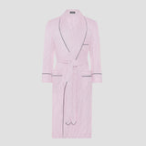 A light pink and white vertically striped bathrobe with black piping trim, featuring a shawl collar, long sleeves, a matching waist tie, and front patch pockets, shown against a solid light gray background.
