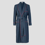 A navy blue long robe with red piping trim, featuring a matching tie belt, front pockets, and a shawl collar, shown against a solid light gray background.