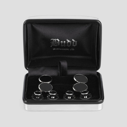 A set of six black and silver cufflinks presented in an open black velvet gift box with 'Budd' embossed on the inside lid, set against a light gray background.