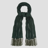 A dark forest green knit scarf with fringed ends, neatly arranged in a looped knot against a solid light gray background.