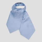A light blue silk necktie with a small repeating geometric pattern, styled in a loose knot on a neutral light gray background.
