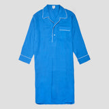 A bright blue long-sleeve pajama shirt with white piping trim, featuring a collar, button placket, and chest pocket, displayed against a solid gray background.