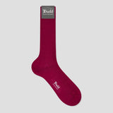 A single dark magenta ribbed crew sock with a gray 'Budd Shirt Makers' brand tag at the cuff, displayed on a light gray background.