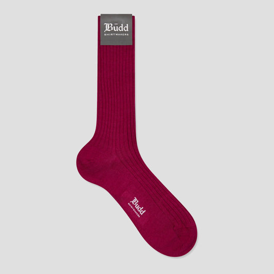 A single dark magenta ribbed crew sock with a gray 'Budd Shirt Makers' brand tag at the cuff, displayed on a light gray background.
