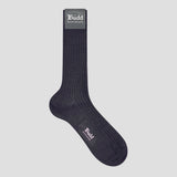 A single dark navy ribbed crew sock with 'Budd Shirtmakers' branding printed on the cuff and foot, displayed against a solid light gray background.