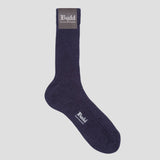A single dark navy blue crew sock with ribbed texture, featuring a gray cuff label and white 'Budd' branding, shown against a solid light gray background.