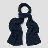 A dark navy blue ribbed knit scarf, styled in a loop at the top, laid flat against a light gray background.