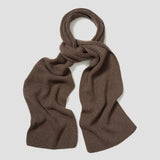 A ribbed knit scarf in a warm brown color, styled in a loose knot and draped against a light gray background.