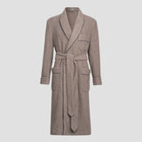A long taupe-brown woolen bathrobe with a shawl collar, self-tie belt, and front patch pockets, featuring subtle dark gray piping details, shown on a light gray background.