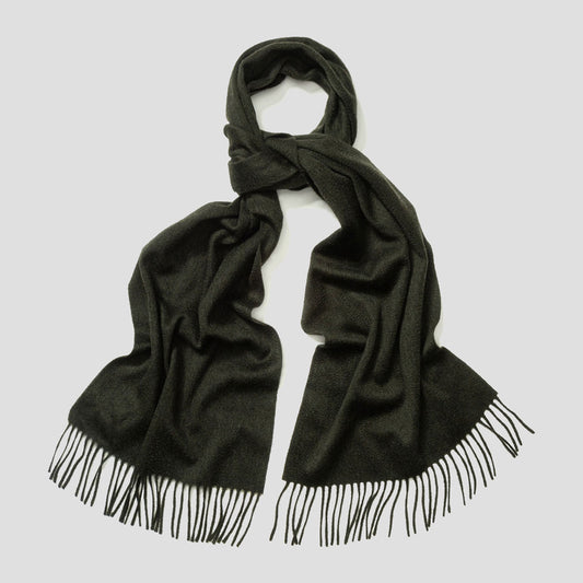 Dark green black colour cashmere scarf with fringed edge, laid on plain grey background