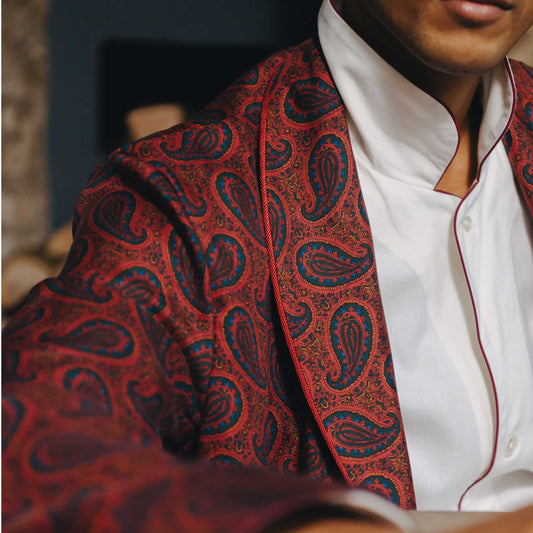 Red paisley patterned dressing gown over a white shirt with a blurred background