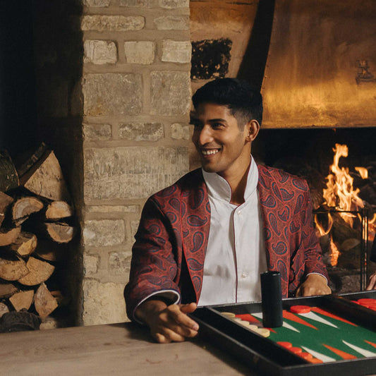 Man playing backgammon in a cozy room with a fireplace