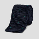 Luxurious navy blue silk knitted tie featuring a sophisticated green polka dot pattern and a classic square-cut tip.