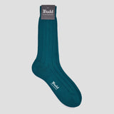A single dark teal ribbed crew sock with a matching paper header card displaying the 'Budd Shirtmakers' brand logo, set against a solid light gray background.