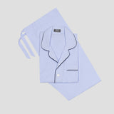 Light blue pajama set including a long-sleeve button-front top with black piping and matching shorts, laid flat on a light gray background.