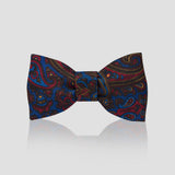 Paisley Madder Silk Adjustable Bow Tie in Royal Blue and Brown on pale plain grey background with soft reflection