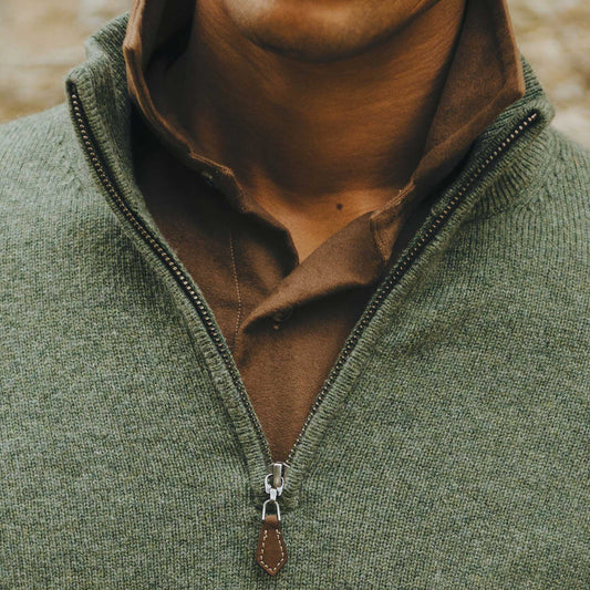 Close up neck shot of male model wearing olive green quarter zip jumper stood outside