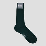 Green sock with brand label Budd on a pale grey plain background