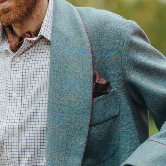 Detail shot of male model wearing a blue herringbone tweed dressing gown