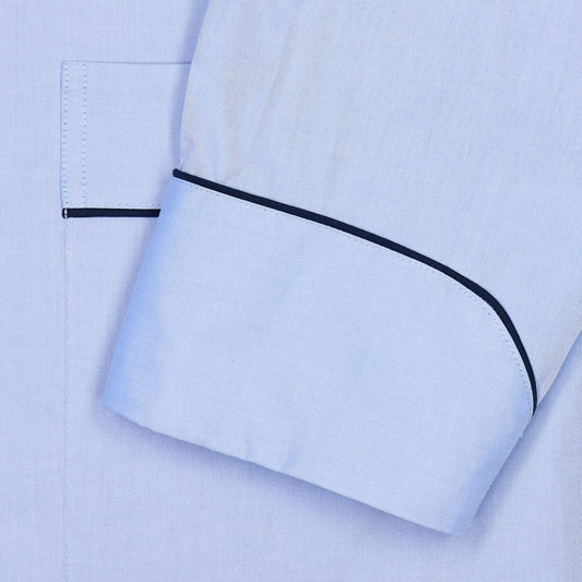 Close-up of a light blue shirt sleeve with black piping trim and a matching black stripe along the cuff edge.