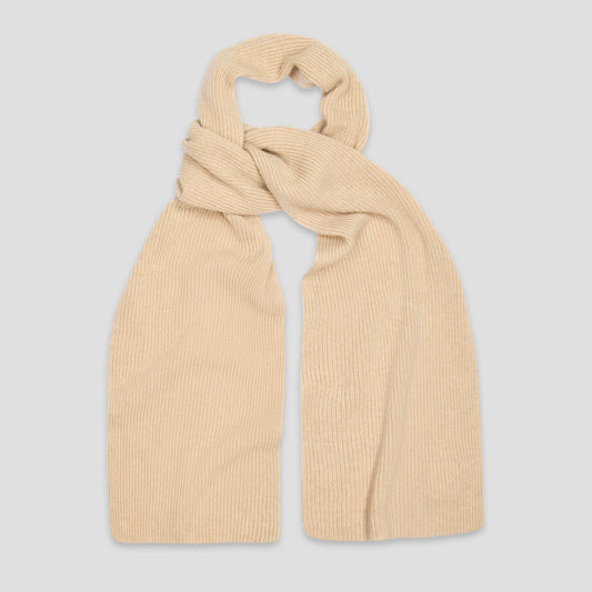A light beige ribbed knit scarf, styled in a loose knot, displayed against a solid light gray background.