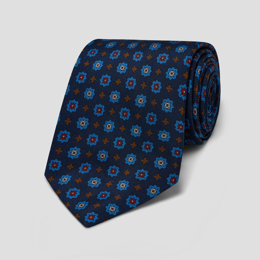 Hand-made navy madder silk tie featuring a sky blue, burgundy, and burnt orange medallion print with an 8.5 cm blade.