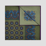A square pocket square with an olive green base, featuring blue and brown ornate patterns on the borders and a matching blue pattern on the folded corner, set against a light gray background.