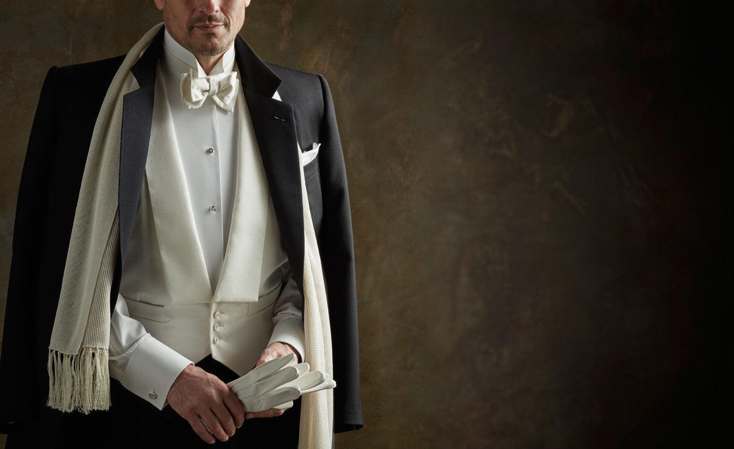 Man wearing White tie ensemble against dark background