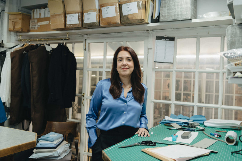 Female shirt cutter in work room stood at cutting board