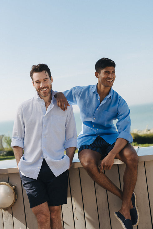 Two men standing on a wooden deck with a scenic background