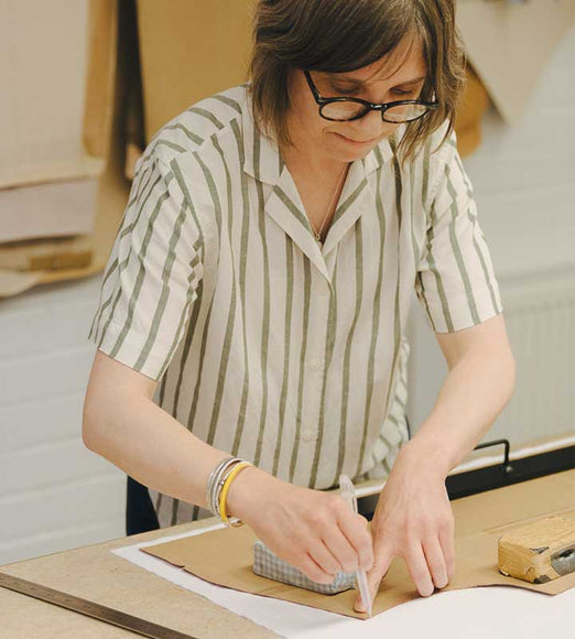 Person working on a shirt bespoke craft project at a table