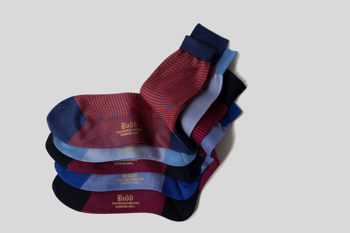 Stack of blue and red socks on plain grey background