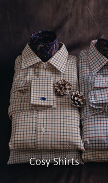 Two plaid shirts with decorative buttons on a dark background, labeled 'Cosy Shirts'.