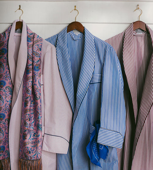 Three dressing gowns in stripe colours hung on hangers