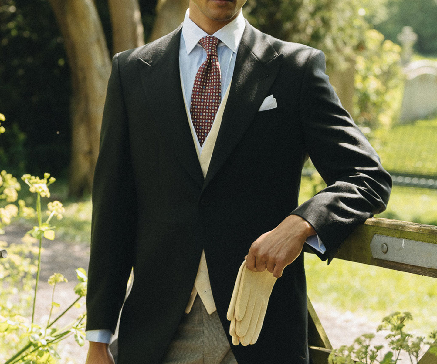 Man stood outside by gate wearing morning wear