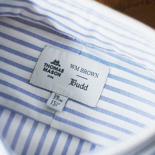 Close-up of a blue and white striped shirt collar showing the Thomas Mason WM Brown Budd size 39 x 151 cm label.