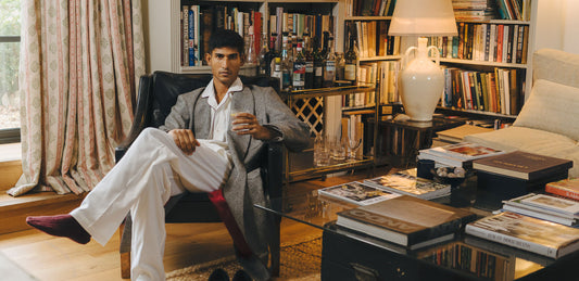 Man sitting in a living room wearing dressing gown with books and decor
