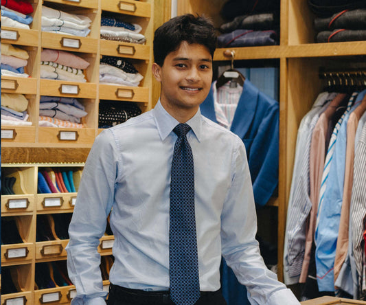 Inam shop advisor stood behind counter in budd shirtmakers shop